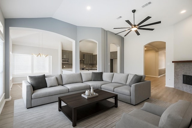 14810 Cascade Bend Ln, Cypress, TX 77429 - living area with lofted ceiling, arched walkways, ceiling fan, light wood finished floors, and a fireplace