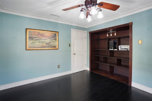 spare room with a ceiling fan, visible vents, crown molding, built in shelves, and baseboards