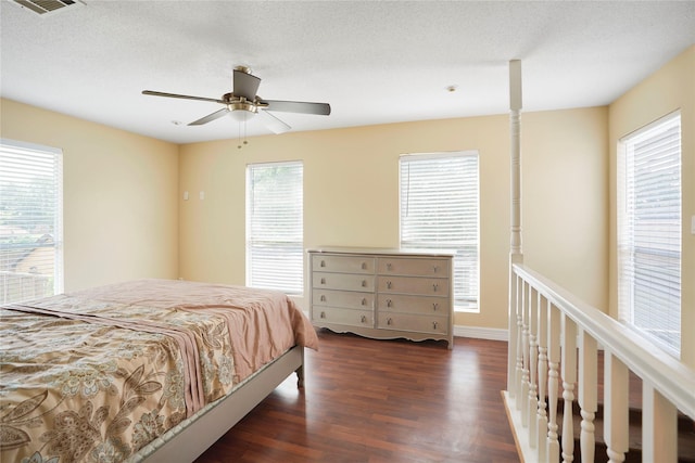 bedroom with a ceiling fan, visible vents, and wood finished floors