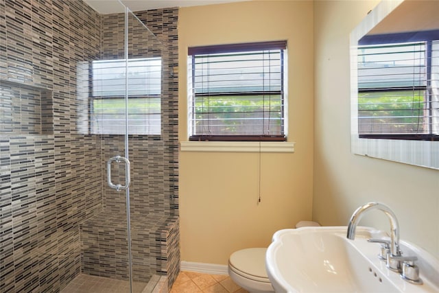 full bathroom featuring a sink, tile patterned floors, toilet, and a shower stall