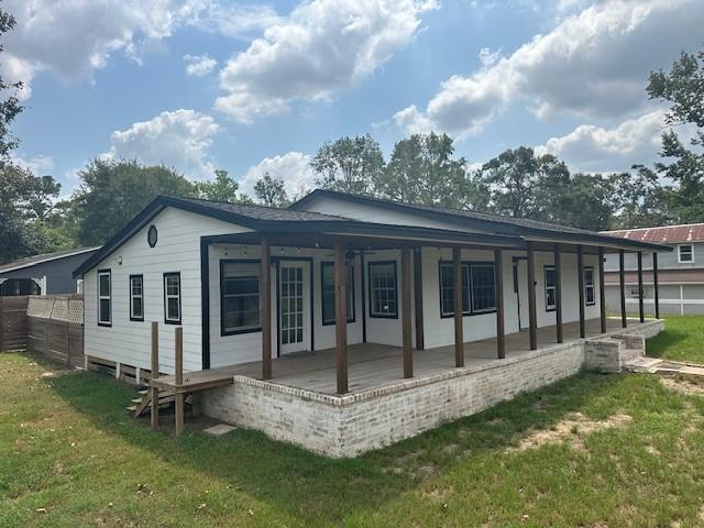 19101 Oak Canyon Dr, Conroe, TX 77385 - rear view of house with a lawn and fence
