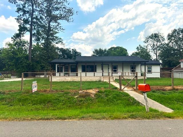 19101 Oak Canyon Dr, Conroe, TX 77385 - ranch-style home with covered porch and fence