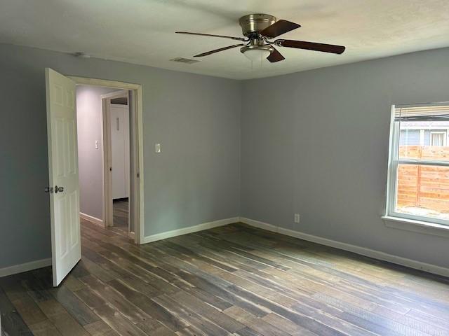 19101 Oak Canyon Dr, Conroe, TX 77385 - unfurnished room with baseboards, a ceiling fan, dark wood-style flooring, and visible vents