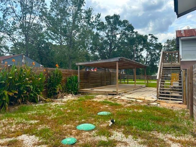 19101 Oak Canyon Dr, Conroe, TX 77385 - view of yard featuring stairway, a wooden deck, a fenced backyard, and a detached carport