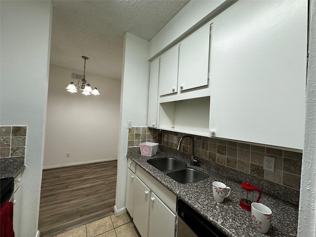 10047 Westpark Dr Unit 73, Houston, TX 77042 - kitchen featuring visible vents, a textured ceiling, white cabinets, a sink, and backsplash