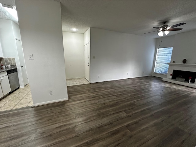 10047 Westpark Dr Unit 73, Houston, TX 77042 - unfurnished living room with baseboards, a textured ceiling, ceiling fan, and wood finished floors
