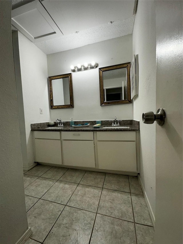 10047 Westpark Dr Unit 73, Houston, TX 77042 - bathroom with double vanity, a sink, baseboards, and tile patterned floors