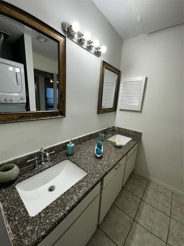 10047 Westpark Dr Unit 73, Houston, TX 77042 - full bathroom featuring stacked washer and dryer, a textured ceiling, a sink, and tile patterned flooring