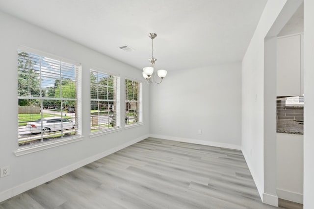 2707 Shawna Lyn Dr, Spring, TX 77373 - unfurnished dining area with baseboards, a chandelier, light wood-style flooring, and visible vents
