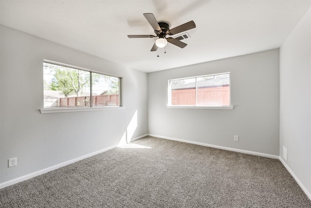 unfurnished room featuring carpet floors, a ceiling fan, baseboards, and plenty of natural light