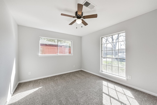 carpeted empty room featuring baseboards, ceiling fan, and visible vents