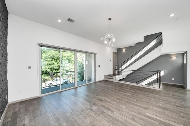 unfurnished living room with baseboards, visible vents, wood finished floors, and stairway