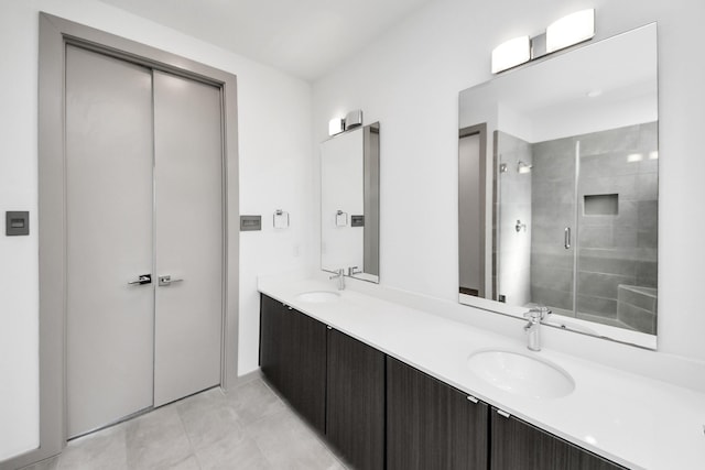 full bathroom featuring a sink, tile patterned floors, a stall shower, and double vanity