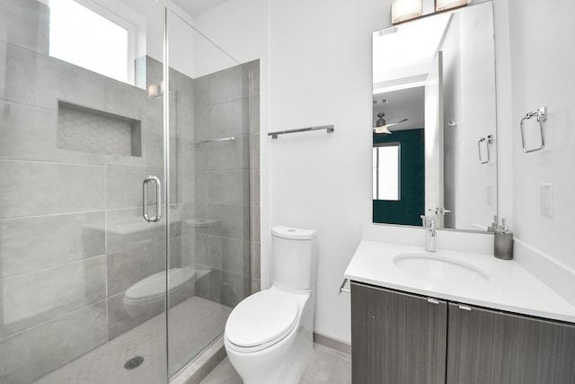 bathroom with vanity, a ceiling fan, toilet, and a shower stall