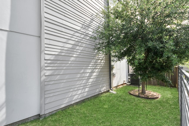view of yard featuring central air condition unit and fence