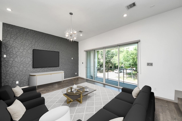 living area with an accent wall, recessed lighting, baseboards, wood finished floors, and visible vents