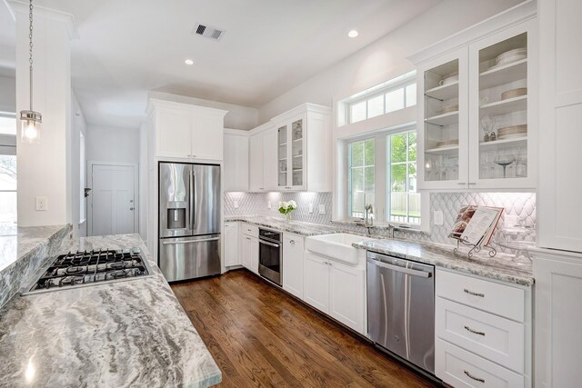 kitchen featuring stainless steel appliances, visible vents, a sink, and light stone counters