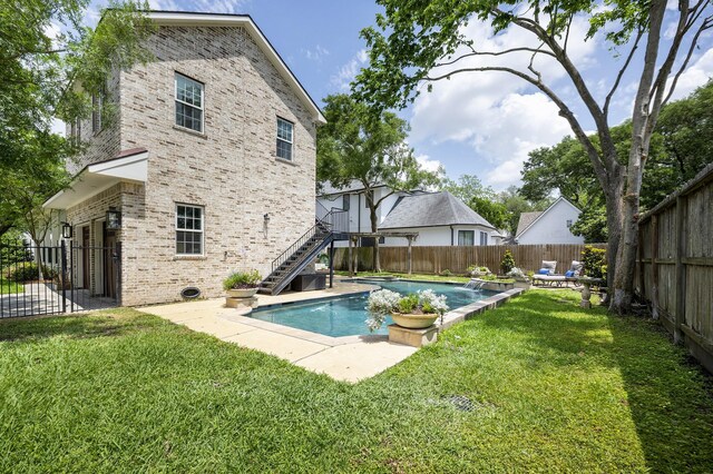 view of swimming pool with a patio area, a fenced in pool, a fenced backyard, a yard, and stairs