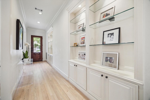 hall featuring visible vents, ornamental molding, light wood-style floors, recessed lighting, and built in shelves