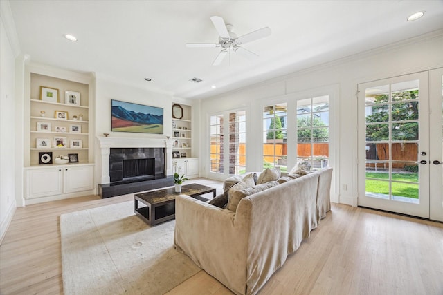 living room with crown molding, plenty of natural light, and visible vents
