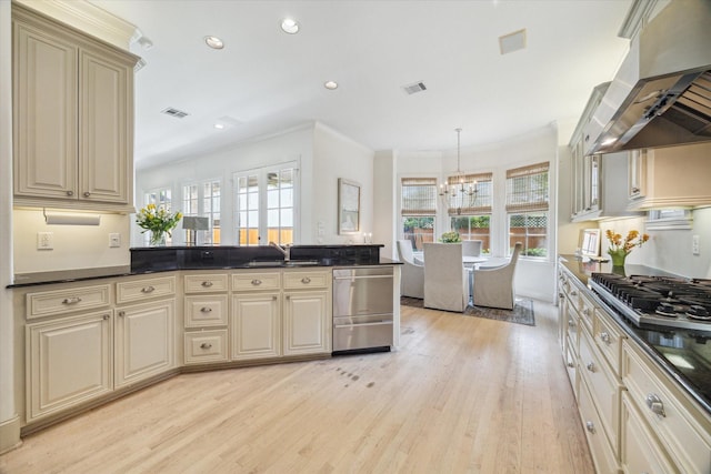 kitchen with cream cabinets, crown molding, dark countertops, ventilation hood, and light wood finished floors