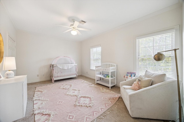 bedroom with crown molding, visible vents, light carpet, and a crib