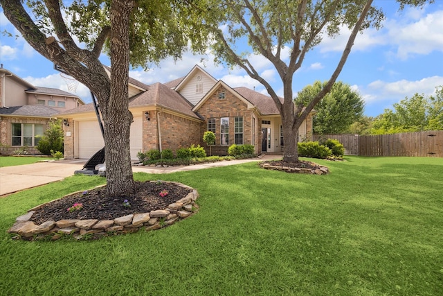 traditional-style house with fence, brick siding, a garage, a front yard, and driveway