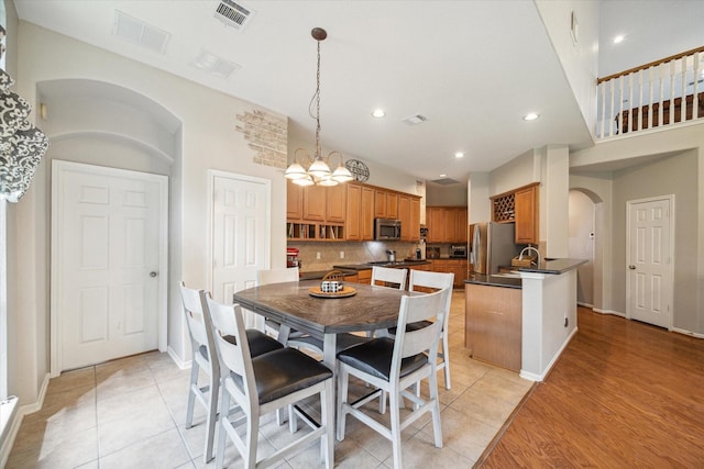 dining room with visible vents, arched walkways, and recessed lighting