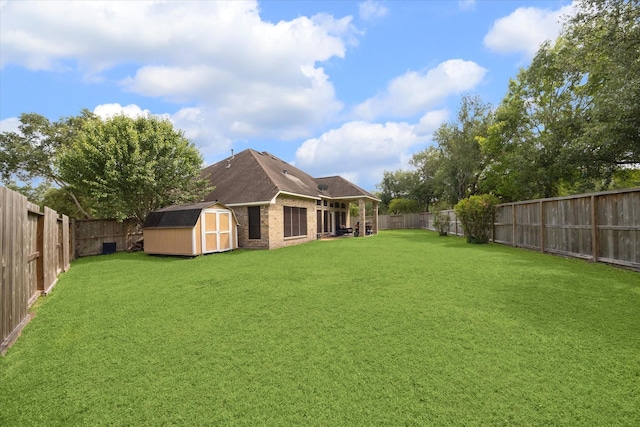 view of yard featuring an outdoor structure, a fenced backyard, and a storage unit