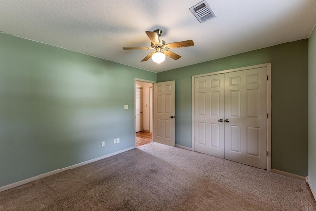 unfurnished bedroom featuring baseboards, carpet, a closet, and visible vents