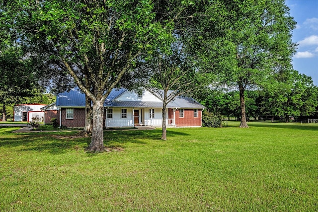 exterior space featuring a lawn, covered porch, and metal roof