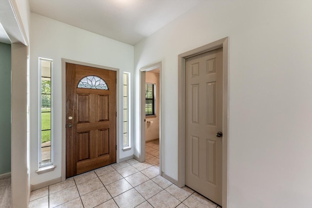 foyer entrance featuring baseboards and light tile patterned flooring