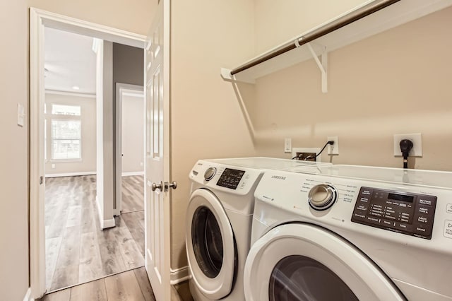 clothes washing area featuring washer and dryer, laundry area, and light wood-style floors