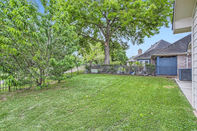 view of yard with a fenced backyard and central AC
