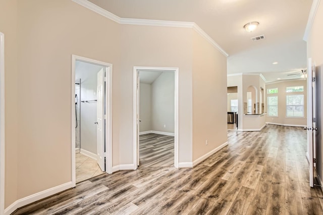 corridor with crown molding, wood finished floors, and visible vents