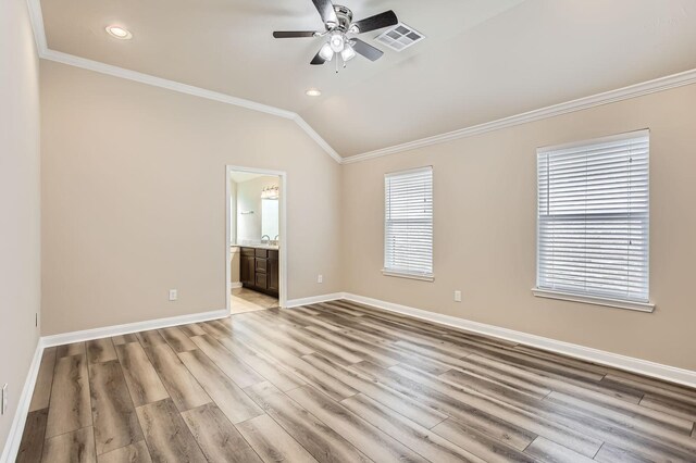unfurnished bedroom featuring visible vents, ornamental molding, lofted ceiling, baseboards, and light wood-style floors