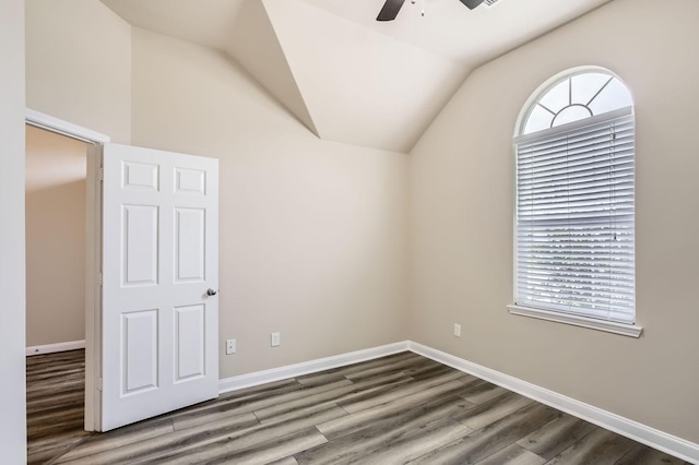 empty room with a ceiling fan, baseboards, wood finished floors, and lofted ceiling