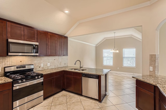 kitchen with a peninsula, arched walkways, a sink, vaulted ceiling, and stainless steel appliances