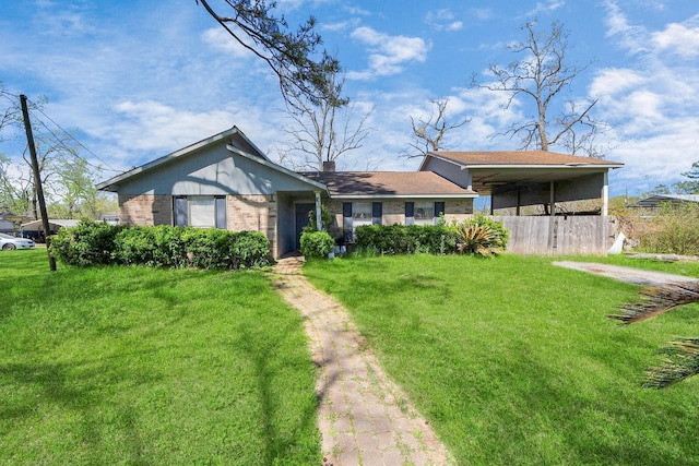 single story home featuring brick siding, a front yard, and a detached carport