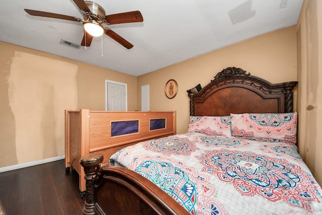 bedroom featuring visible vents, a ceiling fan, baseboards, and wood finished floors