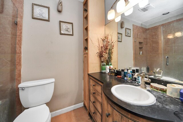 full bathroom featuring a tile shower, vanity, toilet, tile patterned floors, and visible vents