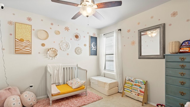 bedroom with a crib, baseboards, wallpapered walls, and carpet floors