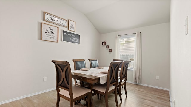 dining room with baseboards, lofted ceiling, and light wood-type flooring