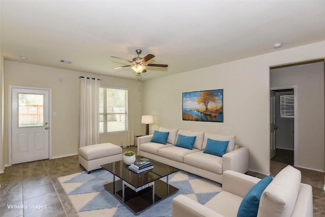 tiled living room featuring baseboards, ceiling fan, and visible vents