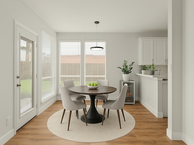 dining area featuring baseboards and light wood-style flooring