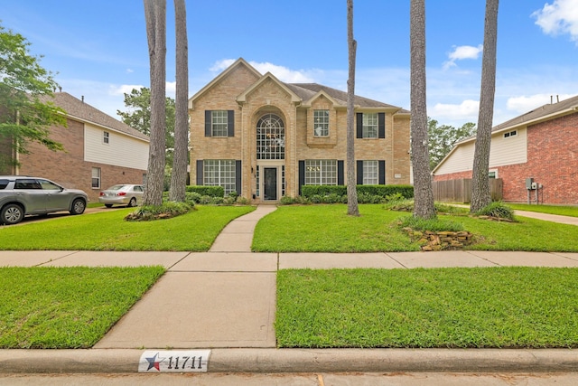 view of front of house with a front yard and brick siding