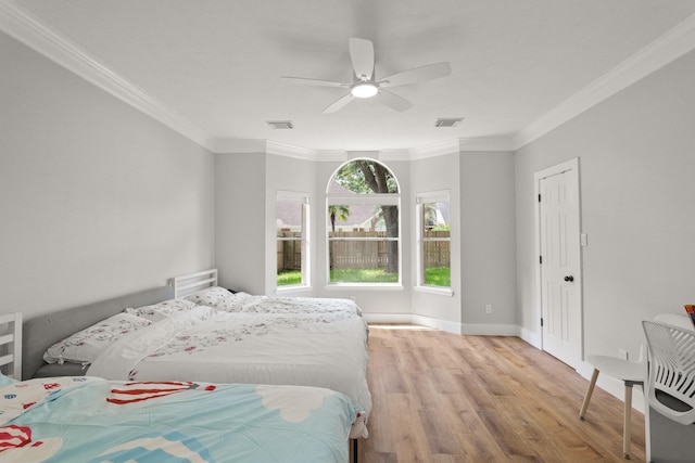 bedroom with crown molding, baseboards, wood finished floors, and visible vents