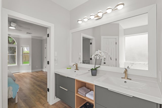 bathroom featuring a sink, a ceiling fan, double vanity, and wood finished floors