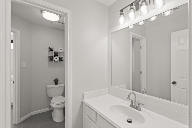 bathroom with vanity, baseboards, tile patterned floors, and toilet