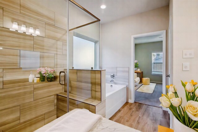 14515 Aston Pine Dr, Houston, TX 77032 - bathroom with baseboards, a shower with door, wood finished floors, and a bath